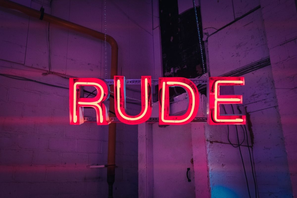A neon sign saying rude.