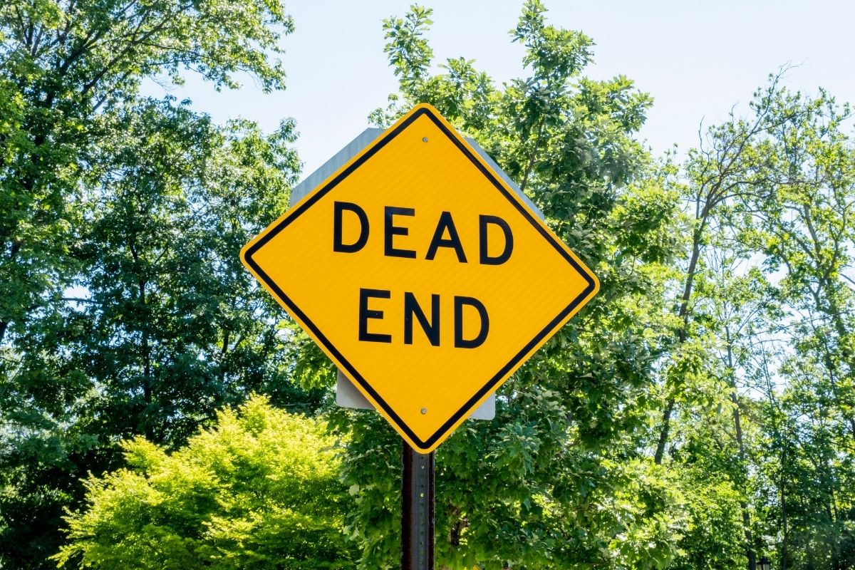 A sign saying dead end in the woods.